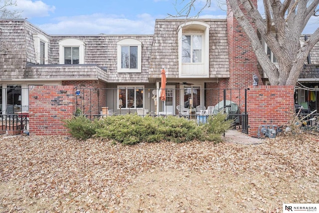 view of front of home with brick siding and mansard roof