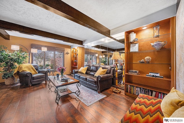 living area with beam ceiling, a textured ceiling, and hardwood / wood-style floors