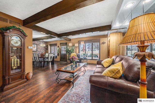 living area with hardwood / wood-style flooring, beamed ceiling, a wealth of natural light, and a textured ceiling