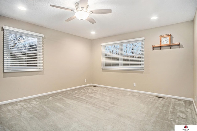 empty room with ceiling fan, a healthy amount of sunlight, and carpet