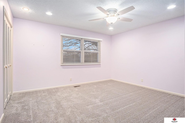 unfurnished room featuring a textured ceiling, ceiling fan, and carpet flooring