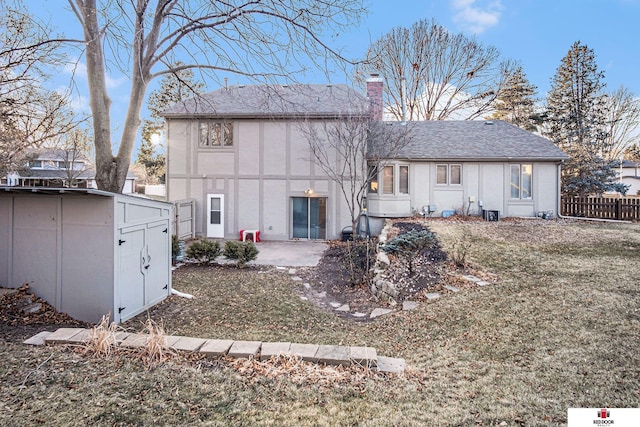 back of house with a shed, a yard, and a patio