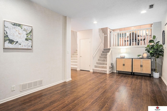 interior space featuring dark wood-type flooring and a textured ceiling