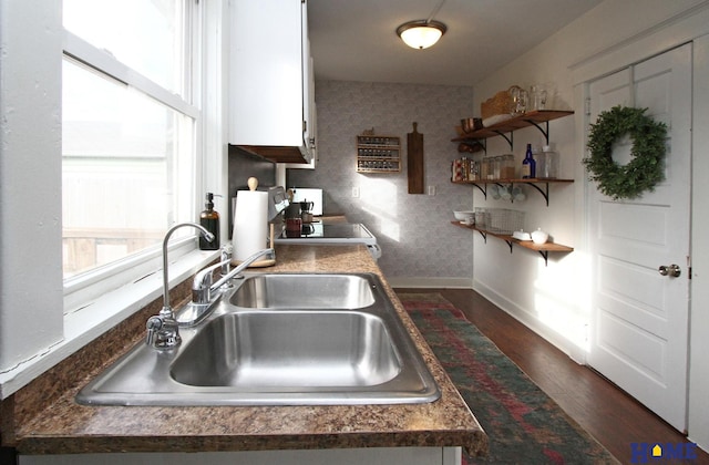 kitchen featuring white cabinetry, dark hardwood / wood-style floors, sink, and stove