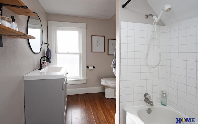 full bathroom with vanity, tiled shower / bath, plenty of natural light, and toilet