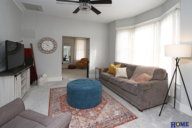 carpeted living room with ceiling fan