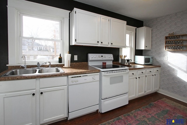 kitchen with white cabinetry, white appliances, dark hardwood / wood-style floors, and sink