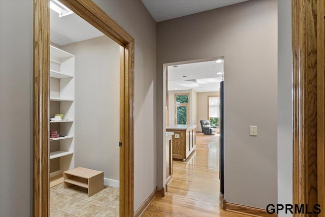 corridor featuring built in features and a textured ceiling