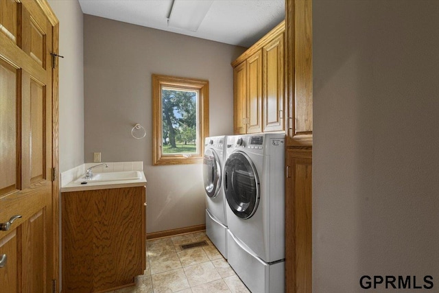 laundry room featuring cabinets, independent washer and dryer, and sink