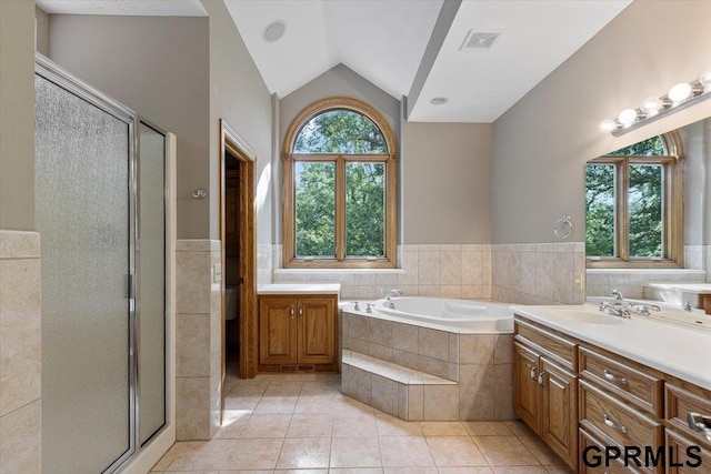 bathroom featuring lofted ceiling, independent shower and bath, tile patterned flooring, and vanity