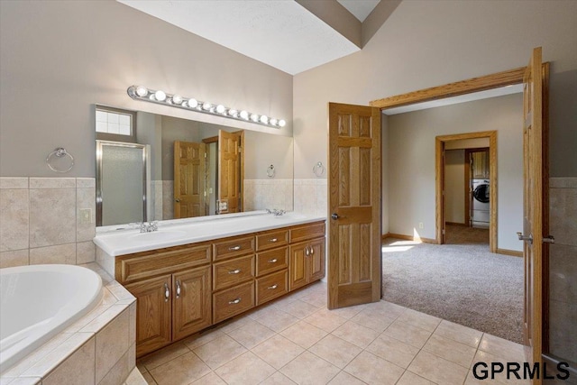 bathroom featuring vanity, washer / dryer, tile patterned floors, and separate shower and tub