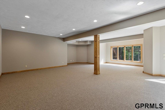 basement featuring light colored carpet and a textured ceiling