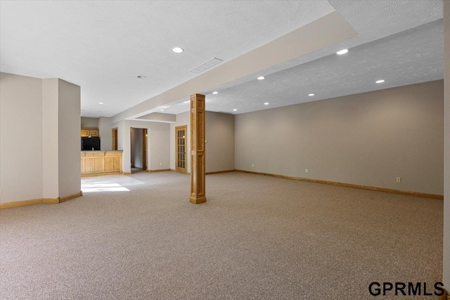 basement featuring light colored carpet and a textured ceiling