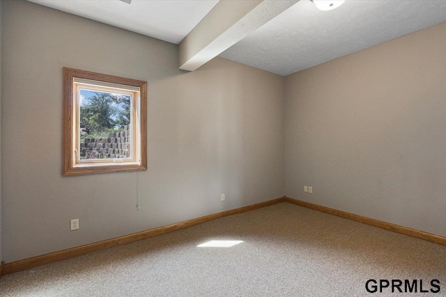 empty room with carpet floors and beamed ceiling