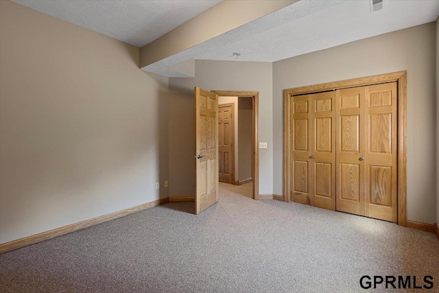 unfurnished bedroom featuring a closet, carpet, and a textured ceiling