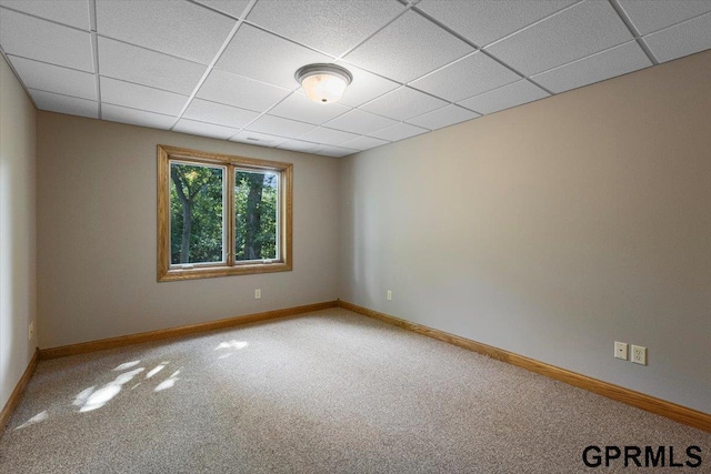 carpeted empty room with a paneled ceiling