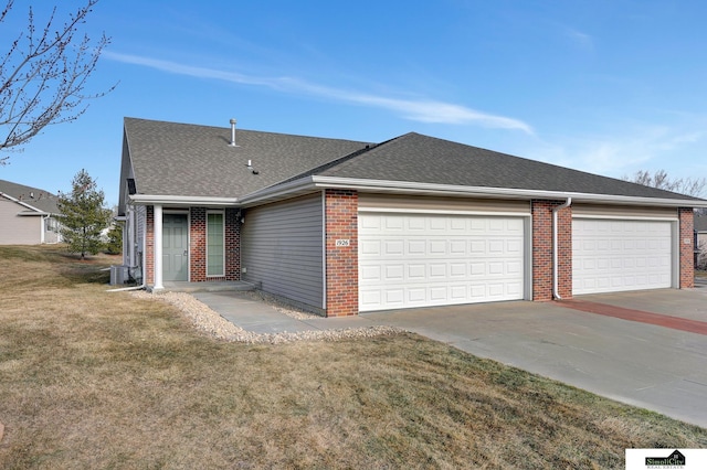 ranch-style home with cooling unit, a garage, and a front lawn