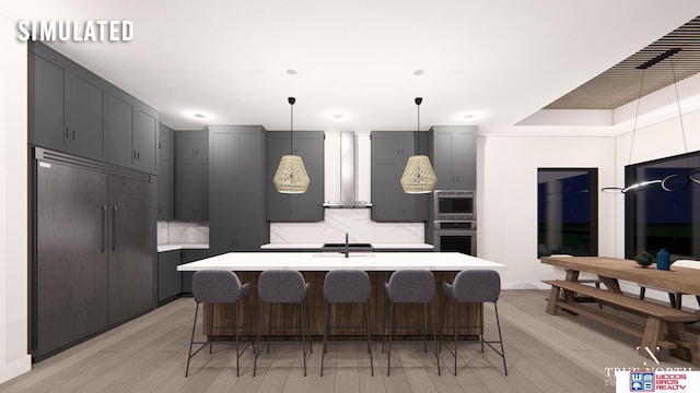 kitchen with wall chimney exhaust hood, a breakfast bar, built in appliances, an island with sink, and light hardwood / wood-style floors