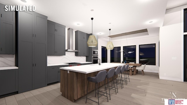 kitchen featuring tasteful backsplash, wall chimney range hood, decorative light fixtures, and an island with sink