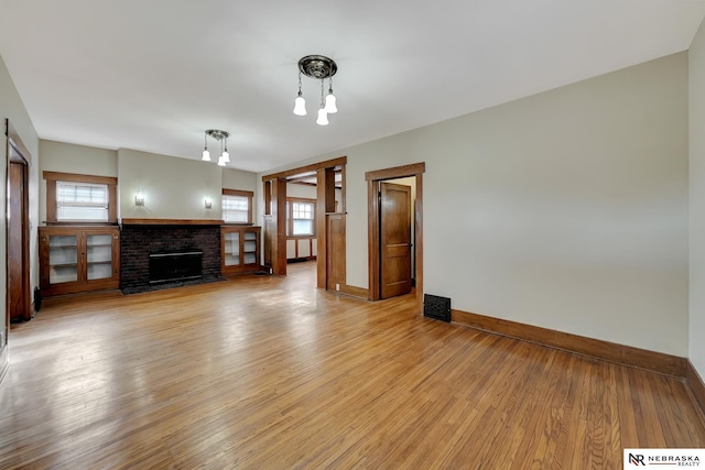 unfurnished living room with a fireplace and light hardwood / wood-style floors