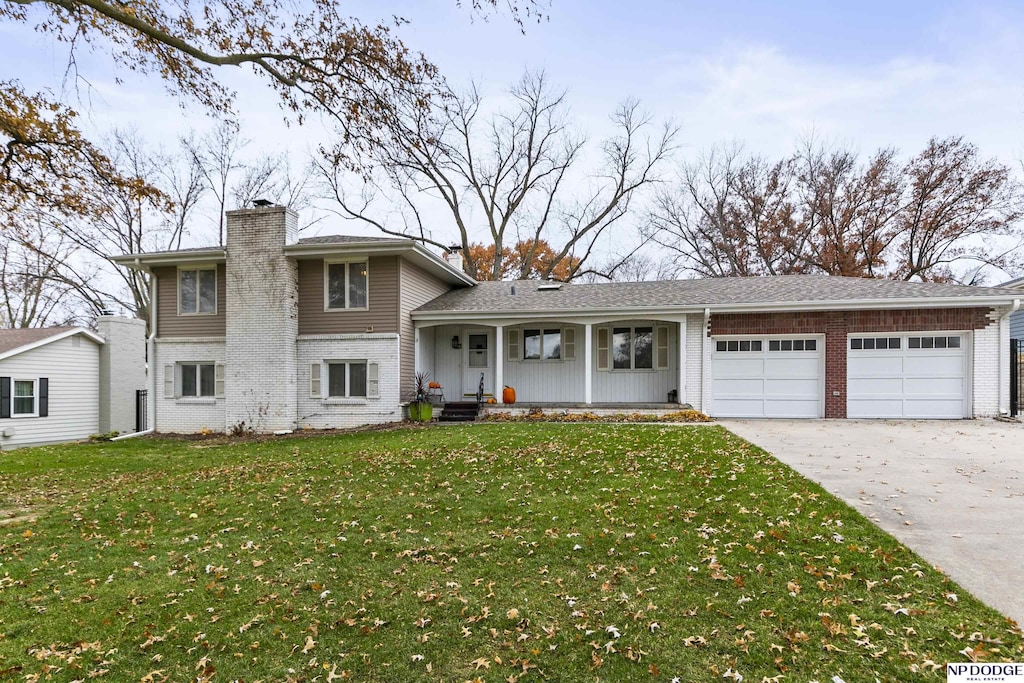 view of front of property featuring a porch, a garage, and a front yard