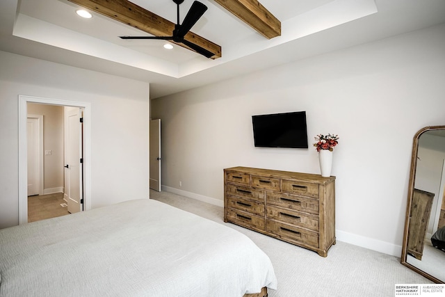 bedroom featuring light colored carpet, a raised ceiling, and ceiling fan