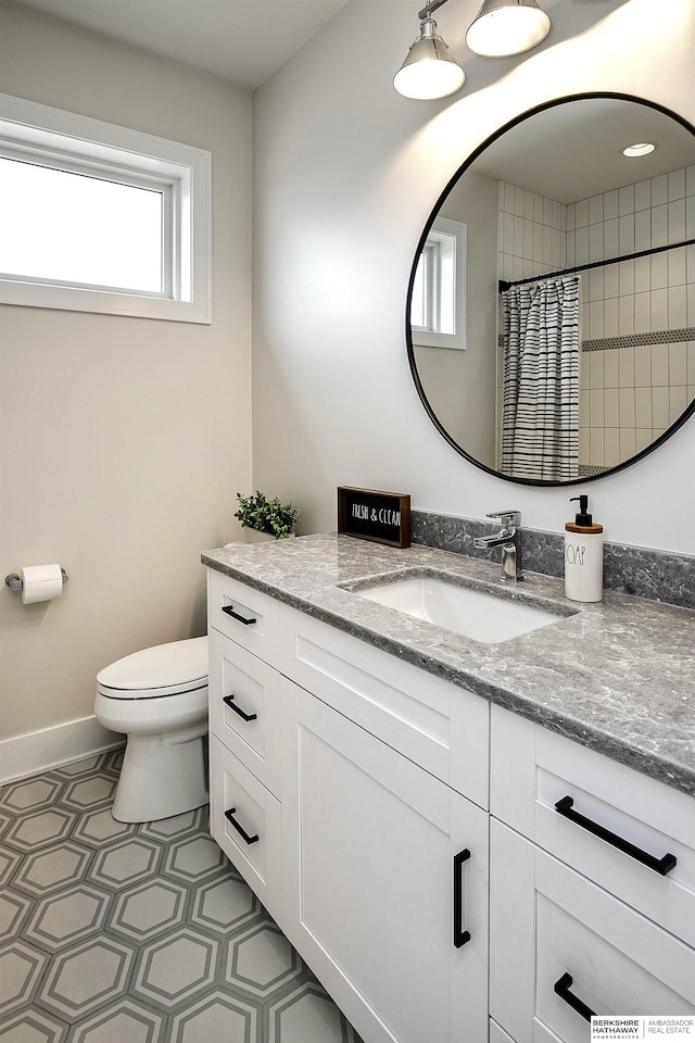 bathroom with vanity, toilet, and walk in shower