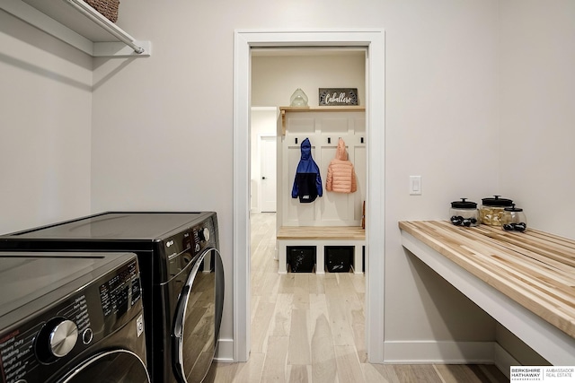 washroom featuring washing machine and clothes dryer and light wood-type flooring