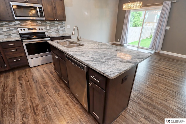 kitchen with sink, dark brown cabinets, dark hardwood / wood-style flooring, stainless steel appliances, and decorative backsplash