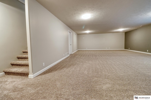 basement featuring carpet and a textured ceiling