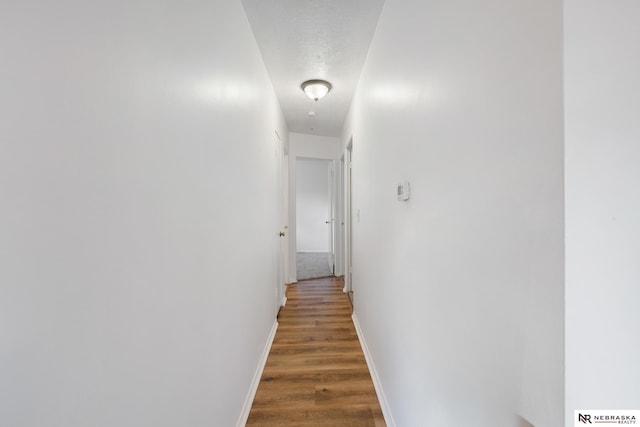 corridor with dark wood-type flooring and a textured ceiling