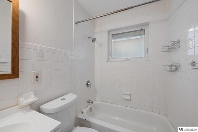 full bathroom with tiled shower / bath combo, vanity, tile walls, and toilet