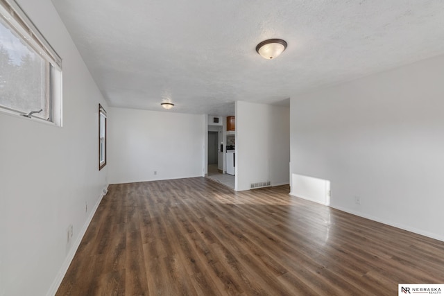 unfurnished living room featuring dark hardwood / wood-style floors and a textured ceiling