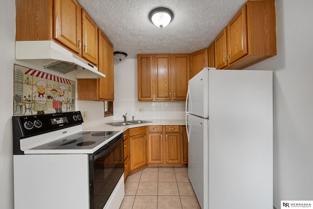 kitchen featuring range with electric cooktop, light tile patterned flooring, sink, white refrigerator, and a textured ceiling