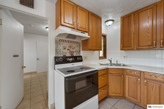 kitchen with electric stove, sink, a textured ceiling, and light tile patterned flooring