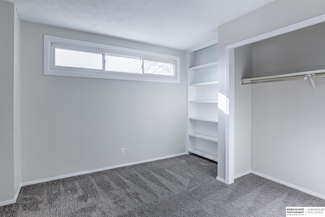 unfurnished bedroom with dark carpet