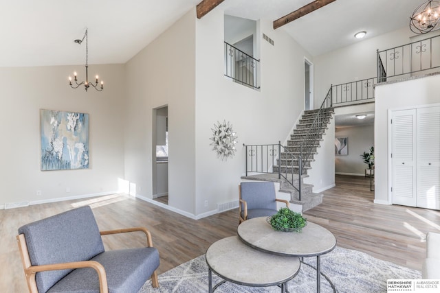 living room featuring beamed ceiling, high vaulted ceiling, a chandelier, and hardwood / wood-style floors