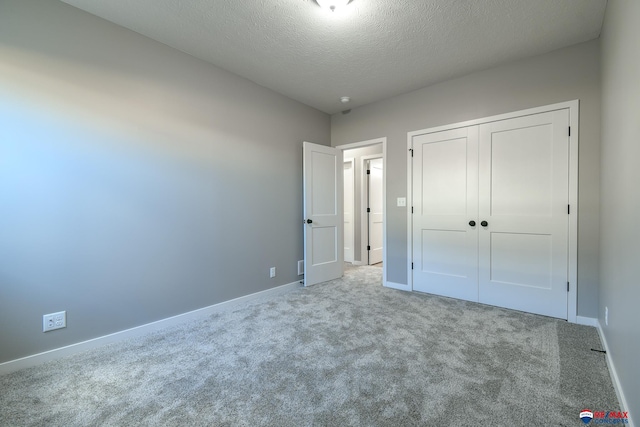 unfurnished bedroom with a closet, a textured ceiling, and carpet