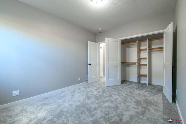 unfurnished bedroom featuring light colored carpet, a closet, and a textured ceiling