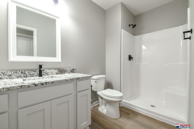 bathroom featuring vanity, hardwood / wood-style floors, toilet, and walk in shower