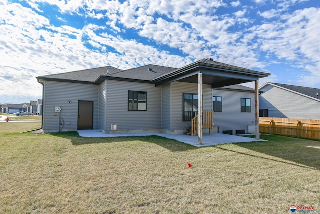 back of property with a yard and a patio area