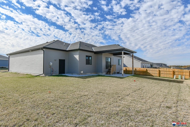 rear view of property featuring a yard and a patio area