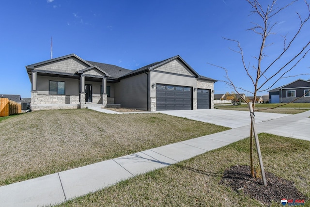 view of front of home featuring a garage, a front yard, and covered porch