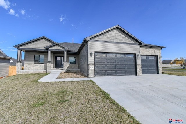 view of front of property with a garage, a front yard, and covered porch