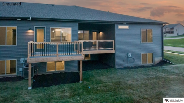 back house at dusk with a wooden deck, a yard, and central AC unit