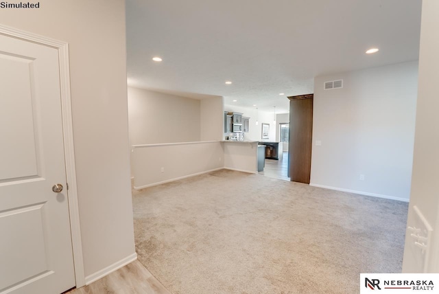 unfurnished room featuring light colored carpet