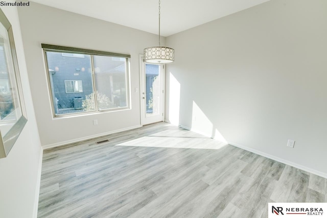 unfurnished dining area featuring light wood-type flooring