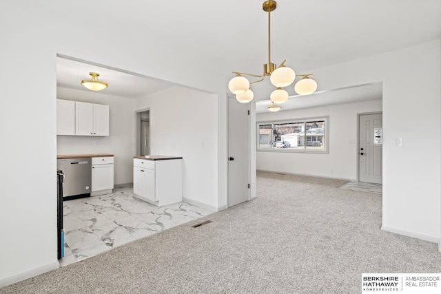 unfurnished dining area featuring an inviting chandelier and light colored carpet