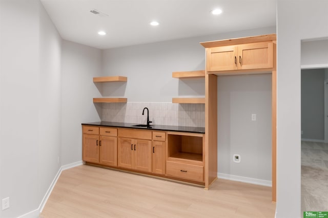 kitchen with light hardwood / wood-style floors, sink, and backsplash