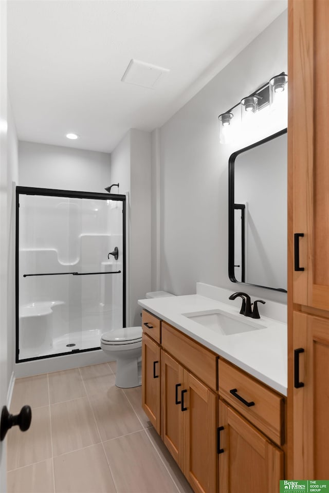 bathroom featuring an enclosed shower, vanity, tile patterned flooring, and toilet